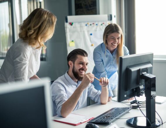 Collega’s lachen samen achter een computerscherm