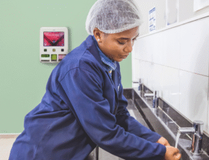 Dameshygiëne producten beschikbaar in toilet met menstruatiedispenser, vrouw wast handen in industrie toilet