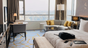 Hotelkamer met bed, zitbank en tafel met stoelen
