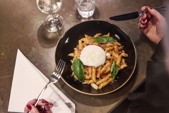 Pasta bord op gedekte tafel met Bio Dunisoft servet