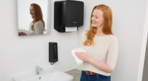 Vrouw droogt handen in toilet met CWS dispensers
